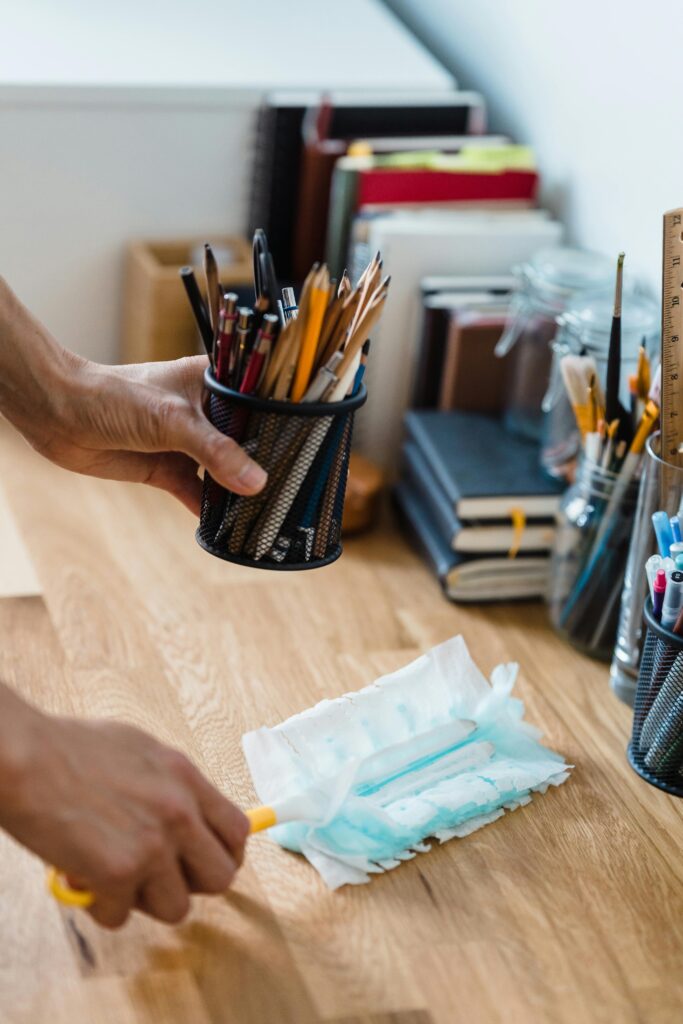 Office Cleaning A clean, organized desk with stationery and dusting supplies for efficient workspace.